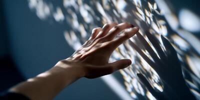 A hand reaching out to touch a wall with a shadow photo