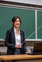 A woman in a business suit holding a stick in front of a laptop photo