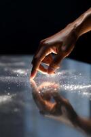 A person touching a table with a sparkly surface photo