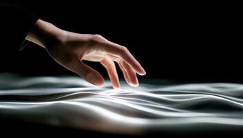 A person's hand touching a surface with a light source photo