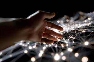 A hand reaching out to touch a network of lights photo