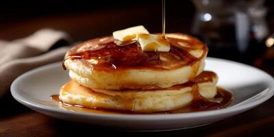 Stack of pancakes topped with butter and syrup photo