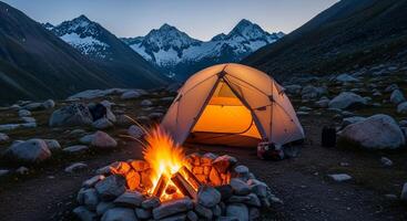 Illuminated Tent and Campfire in Mountain Valley at Dusk photo