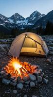 A tent is set up in front of a campfire photo