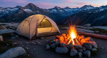 Illuminated Tent and Campfire Under Mountain Peaks at Dusk, Camping Adventure. photo