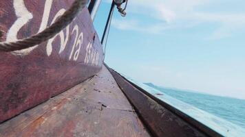 Boat trip to exotic island with lush scenery on coastline, serene voyage across coastal waters of Thailand leads to beautiful island with sunlit waves and greenery. video