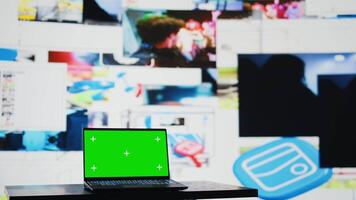 Laptop shows green screen mockup next to modern web design social network platforms, visual representation of trends and mobile interaction. Empty space for user experience. Camera B. video