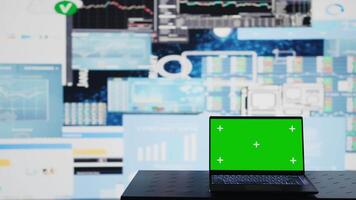 Isolated green screen on the laptop next to fintech monthly reports, ensuring a strategy for corporate success. Showcasing trends and infographics KPI metrics to improve activity. Camera B. video