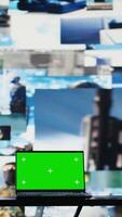Vertical Green screen on laptop next to military satellite imagery of enemy forces, high tech armed forces command center used to gather data helpful for war planning. Secure global operations. Camera B. video