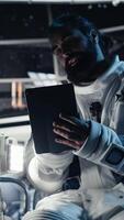 Vertical Close up of scared starship crew member responding to alien hostile presence critical alert. Cosmonaut frightened by unseen extraterrestrial form attacker approaching in orbital station cockpit video