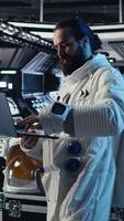 Vertical Cosmonaut troubleshooting spaceship hardware using tablet during mankind survival expedition. Researcher studying star charts on device during human expansion in space mission parameters, camera A video