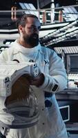 Vertical Starship cockpit glowing as cosmonaut watches unknown alien vessel approach from deep space. Man reacts to unidentified extraterrestrial presence hovering near orbital station, camera A video