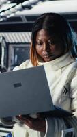 Vertical Close up of astronaut using tablet to check logs after completing red planet surface mission. Cosmonaut leaving Mars, updating flight log on device to return home, camera B video