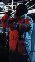 Vertical Cheerful astronaut doing videocall with Earth command center while aboard orbit station, sharing mission update. Happy cosmonaut talks with ground center team during communication link, camera A video