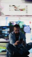 Vertical Paranoid guy suffers from emotional damage caused by obsessive social media use. Young man being overwhelmed by excessive information and comparison affecting his self esteem. Camera B. video