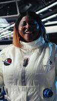 Vertical Female astronaut performing routine maintenance in starship exploring deep space, travelling to Mars. Woman in spacecraft navigating orbital trajectory after leaving Earth, camera A video