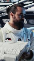 Vertical Cosmonaut using tablet in spaceship conducting safety checks during mankind survival expedition. Astronauts monitoring life support systems during human expansion in space mission, camera B video