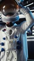 Vertical Joyous astronaut greeting command center researchers during videocall, presenting analysis findings. Smiling orbit station crew member provides scientific findings to Earth team, camera A video