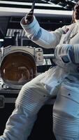 Vertical Astronauts reviewing onboard analytics on isolated screen tablet before stepping outside starship. Cosmonauts verifying parameters on chroma key device after landing on planet, camera A video