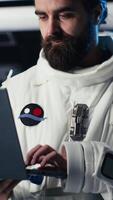 Vertical Astronaut using tablet to check analytics after completing red planet surface mission on unfamiliar planet. Cosmonaut leaving Mars, inputting navigation coordinates on device to return home, camera B video