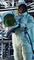 Vertical Space helmet next to laptop in starship showing sensors calibrating software during orbital flight. Cosmonaut gear equipment prepared for planetary expedition and notebook displaying star charts video