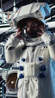 Vertical Jolly astronaut waves hand during videocall with Earth command center, documenting results from space experiments. Cosmonaut salutes ground center team, sharing research observations, camera A video