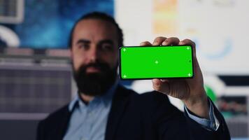 Business specialist showing phone display with copy space, exploring new investment ideas after studying monthly reports with financial data in workspace. Development. Camera A. video