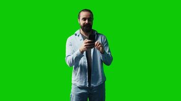 Young carefree man checking his mobile phone against green screen backdrop, being connected online on social network apps or texting messages. Social media platforms. Camera B. video