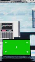 Vertical In a business related space, laptop display shows green screen to help with strategy planning with financial data. Representing modern artificial intelligence and productivity for growth. Camera B. video