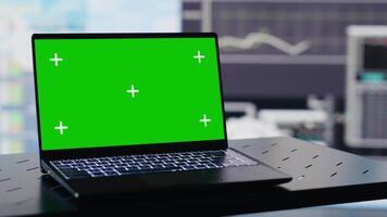 Empty business space has a laptop display with green screen, showcasing infographics and reports for decision making and strategy planning. Artificial intelligence data visualization. Camera A. video