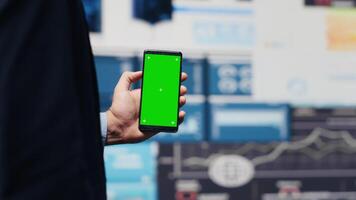 Male administrator uses green screen phone to explore new growth strategy with insight and analytics in a digital workspace. Representing modern business intelligence and productivity. Camera A. video