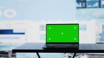 Laptop with copy space display on empty desk next to infographics reports, showcasing finance graphs and strategy tools for new investment and decision making. Business growth. Camera A. video