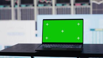 Isolated green screen on the laptop next to fintech monthly reports, ensuring a strategy for corporate success. Showcasing trends and infographics KPI metrics to improve activity. Camera A. video