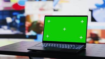 Laptop running isolated chroma key screen next to social media web design platforms, visual representation of trends and mobile interaction. Empty space with device and online engagement. Camera A. video