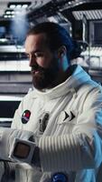 Vertical Astronaut conducting safety checks before stepping out for scheduled operations outside space station. Cosmonaut checks gear diagnostics on device, preparing to leave after landing on Mars, camera A video