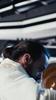 verticale portrait de joyeux astronaute en portant casque Faire programmé opérations dans vaisseau explorant Profond espace. optimiste cosmonaute inspecter vaisseau spatial coque après en quittant planète, caméra b video