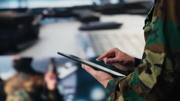 Defense forces officer reviews surveillance and digital systems, getting combat ready with warfare strategies and battlefield details. War planning operations in military control center. Camera A. video