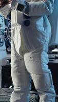 verticale portrait de joyeux astronaute en portant casque performant routine entretien dans vaisseau explorant Profond espace. content cosmonaute navigation orbital trajectoire dans vaisseau spatial après en quittant planète, caméra une video