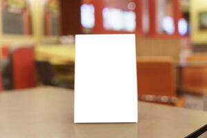 Mock up Menu frame standing on wood table in restaurant space for text. photo