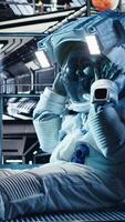 Vertical Astronaut studying star charts on laptop, discussing with colleague during space mission. Teamworking cosmonauts look at galaxy visualization on notebook during mankind survival expedition, camera A video