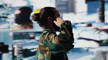 Veteran does military salute after reviewing satellite data in a control center, working on war planning tactics with battlefield details. High tech army environment for national safety. Camera A. video