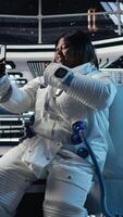 Vertical Astronaut using green screen smartphone to text friends before landing spaceship on Mars. Woman using chroma key phone to chat with family during mission to red planet surface in deep space, camera A video