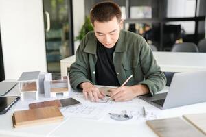 a Architecture man is working on a project at a desk photo