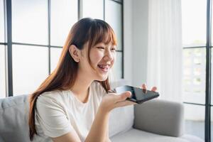 woman using smartphone while sitting on couch. photo