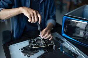 IT Engineer installing Hardware working on a computer with a screwdriver. photo