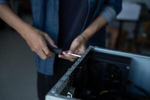 IT Engineer installing Hardware holding a screwdriver to a computer case photo