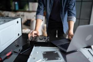 IT Engineer installing Hardware working on a laptop computer with a motherboard photo