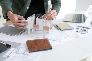 person is working on a model of a house. photo