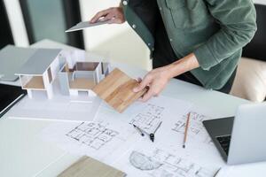 a person is working on a project with a laptop and a blueprint photo