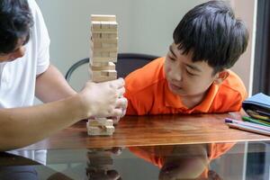 a man and boy playing with wooden blocks on a table photo
